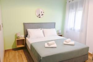 a bedroom with a bed with two towels on it at My Gytheio Apartment in Gythio +8 photos