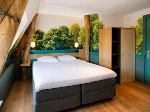 a bedroom with a bed and a large window at Boutique Hotel, Restaurant & Wellness Westerburcht in Westerbork