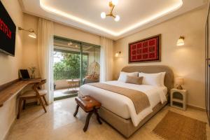 a bedroom with a bed and a desk and a window at Babylone Appart & Pool, Hivernage in Marrakesh +24 photos