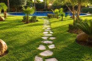 a stone path in a yard with a pool at Babylone Appart & Pool, Hivernage in Marrakesh