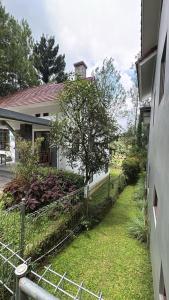 a fence in front of a house with a yard at villa NC3 31 Kota Bunga in Cikundul