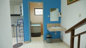 a bathroom with blue walls and a sink and a mirror at villa NC3 31 Kota Bunga in Cikundul +60 photos