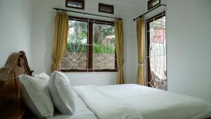 a bedroom with a bed and a large window at villa NC3 31 Kota Bunga in Cikundul