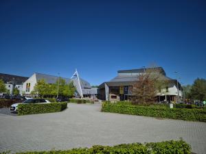 a parking lot in front of a building with a wind turbine at Sweet&City HOUSE in Saint-Vith