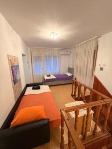a living room with two beds and a couch at Apartamani Evelin in Veliko Gradište +3 photos