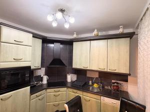a kitchen with white cabinets and a sink in it at Apartamani Evelin in Veliko Gradište