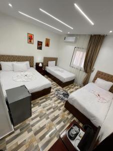 a room with two beds and a flat screen tv at Basha Pyramids Best View in Giza