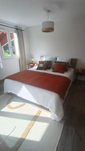 a bedroom with a large bed with red and white sheets at Chambre d'hôtes Bidegaina in Ahetze