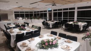 a banquet hall with white tables and chairs and flowers at אשתורי - ASHTORI in Bet Sheʼan +16 photos