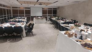 a large room with tables and chairs with flowers on them at אשתורי - ASHTORI in Bet Sheʼan