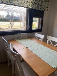 a dining room table with chairs and a window at Huoneisto Rivimerta, Siikajoki in Siikajoki