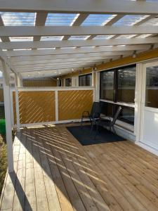 a deck with a pergola and a chair on it at Huoneisto Rivimerta, Siikajoki in Siikajoki +2 photos