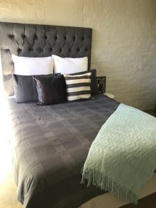 a bedroom with a bed with a gray comforter and pillows at Home at heart in Johannesburg