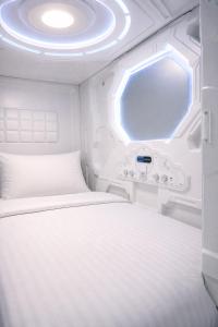 a white bed in a room with a window at Beddy Hostels in Madrid