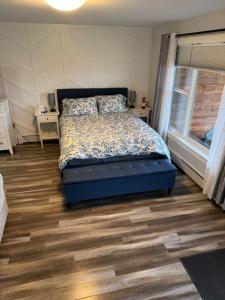 a bedroom with a bed and a wooden floor at Studio Guest Apartment in Dartmouth in Halifax