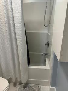 a bathroom with a white shower curtain and a toilet at Studio Guest Apartment in Dartmouth in Halifax +10 photos