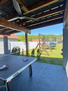 a ping pong table on a patio with a playground at Sarajevo Villa Sunce in Ilijaš