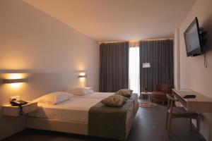 a hotel room with a large bed and a desk at Chez Maria Julia Boutique Hotel in Praia