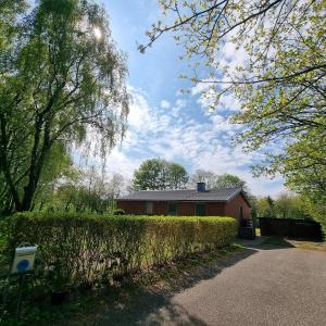 a house with a hedge in front of a house at Karlskovhuset in Give