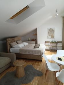 a bedroom with a bed and a couch and a table at Apartman Nadja in Podgorica