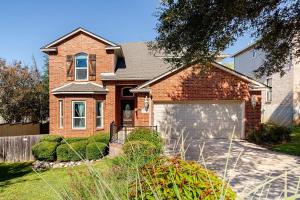 a brick house with a garage in a yard at Prospect Haus Stone Oak in San Antonio