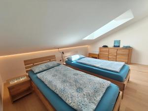 a bedroom with two beds and a dresser at Am Weiher mit Terrasse in Hergensweiler