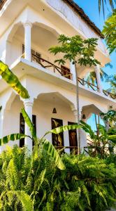 a white house with trees in front of it at Karibuni Marafiki in Bwejuu