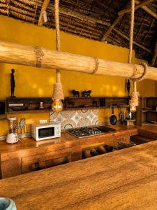a kitchen with a stove and a microwave at Karibuni Marafiki in Bwejuu