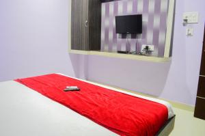 ウッジャインにあるHotel Royal Palace - 150 Meters from Mahakal Templeのベッドに赤い毛布とテレビが備わる客室です。 +11枚の写真