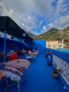 a balcony with several tables and chairs on a ship at La Joya Hostel Chafchaouen Cozy Stay with Terrace in Chefchaouen