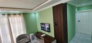 a bathroom with a chair and a tv on the wall at Mountain-Ridge Lux Stay in Rustenburg