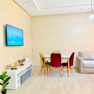 a living room with a table and chairs at 2BR Apt with Pool View in City Center in Oulad Akkou