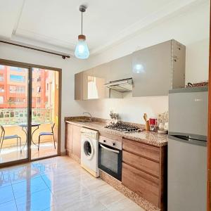 a kitchen with a stove and a dishwasher at 2BR Apt with Pool View in City Center in Oulad Akkou