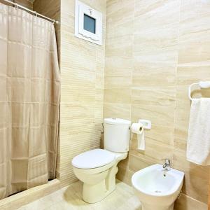 a bathroom with a toilet and a sink at 2BR Apt with Pool View in City Center in Oulad Akkou +6 photos