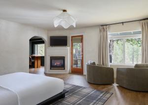 a bedroom with a white bed and a fireplace at All Seasons River Inn in Leavenworth
