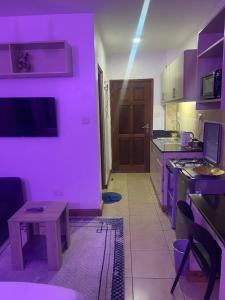 a purple kitchen with a table and a purple wall at West suites kisauni road in Nairobi
