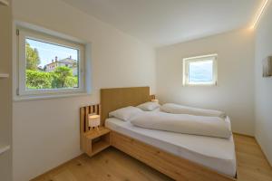 a white bedroom with a bed and a window at Ferienwohnungen Atz in Termeno +34 photos
