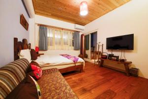 un soggiorno con divano e TV a schermo piatto di Tang Chao B&B a Jiaoxi