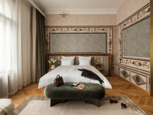 a bedroom with a large bed and a green ottoman at The House 14 in Krakow