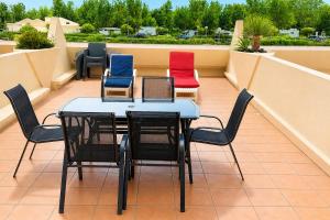 a table and chairs sitting on a balcony at Naturiste Cap d'Agde Héliopolis K 106 in Cap d'Agde