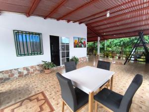 a dining room with a white table and chairs at Casa Finca la Casona con Piscina Privada - Cerca al Parque Tayrona in Santa Marta