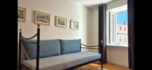 a couch sitting in a room with a window at Apartments San Rocco in Piran