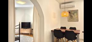 a dining room with a table and black chairs at Apartments San Rocco in Piran