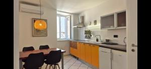 a kitchen with a wooden table and black chairs at Apartments San Rocco in Piran