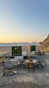 an rv parked in the desert with tables and benches at The Out Resort in Sinādil