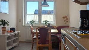 a kitchen with a table and chairs and two windows at Haus Landlust - OG in Edersee