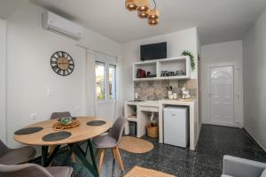 a kitchen with a table and chairs in a room at Artemis Cozy Home in Péran Triovasálos