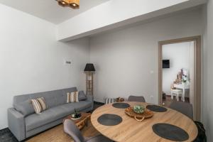 a living room with a table and a couch at Artemis Cozy Home in Péran Triovasálos