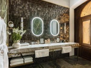 a bathroom with two sinks and two mirrors at The House 14 in Krakow