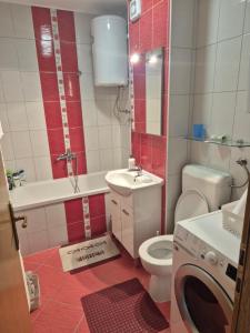a bathroom with a toilet and a sink and a washing machine at Apartman Dobrinja in Sarajevo +11 photos